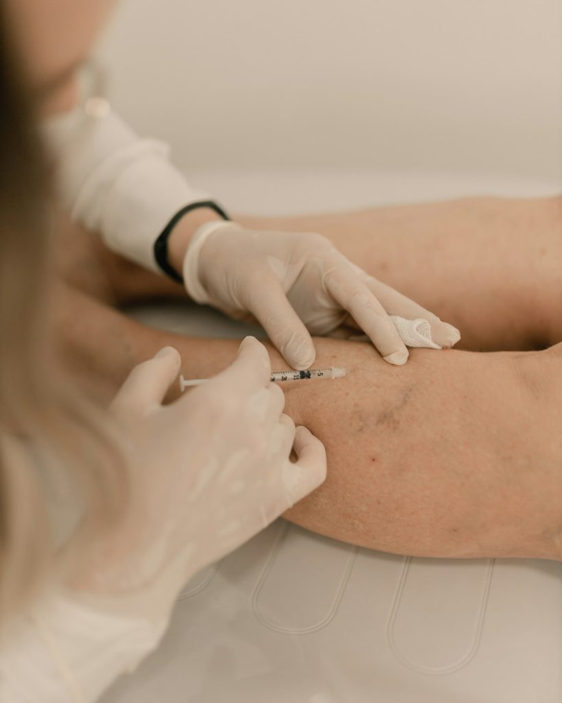 Medica examinando a pele do braco de uma paciente durante consulta de dermatologia clinica